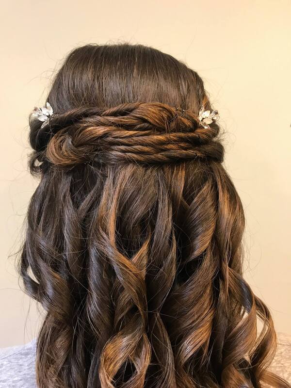 Prom hair style close up with curls and flower pins